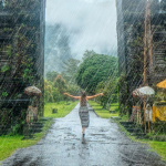 A woman standing outside in Bali while it is raining