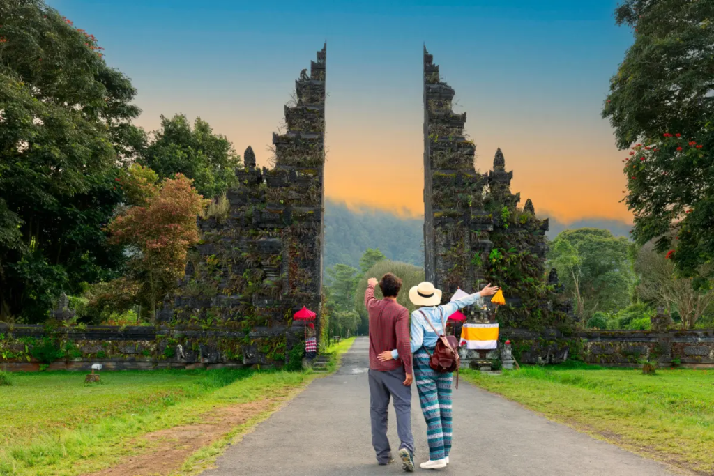 Two tourists standing in front of a Bali attraction