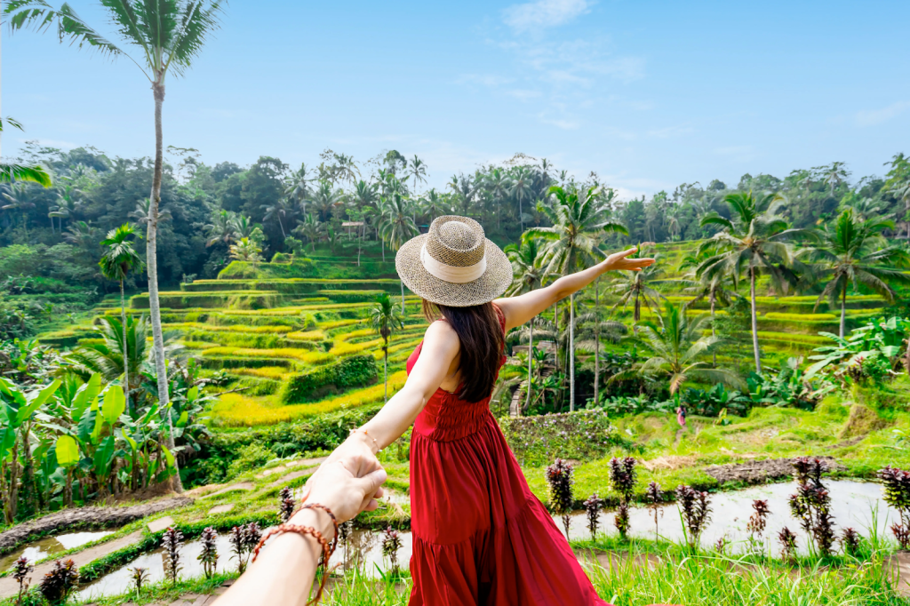 A woman in a red dress standing in the rice fields in Bali