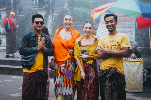 Tourists standing with local Balinese in front of a traditional temple