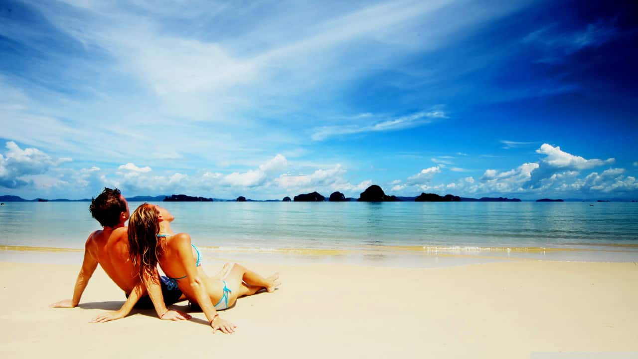 A couple on their honeymoon relaxing on a beach