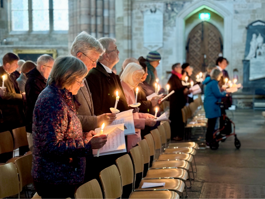 Christian people holding candles in a church