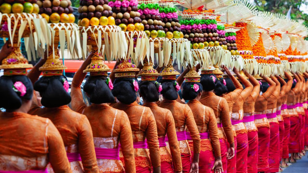 Balinese women standing in a line with large fruit offerings for a ceremony