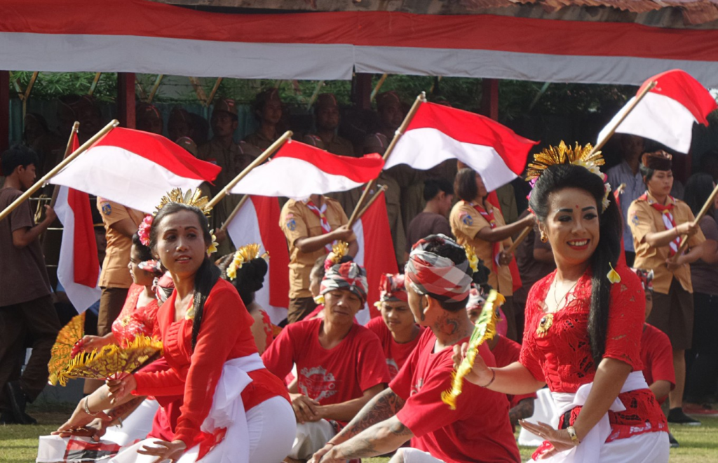 Indonesian people in traditional clothing holding Indonesian flags