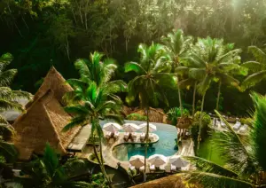 Aerial view of Viceroy Bali’s main infinity pool surrounded by lush tropical jungle, private cabanas, and luxury resort villas in the hidden Valley of the Kings in Ubud