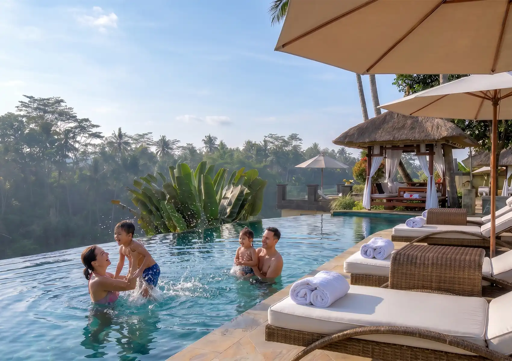 A joyful family of four splashing and playing together in a stunning infinity pool overlooking a lush tropical jungle during a perfect family holiday in Ubud.