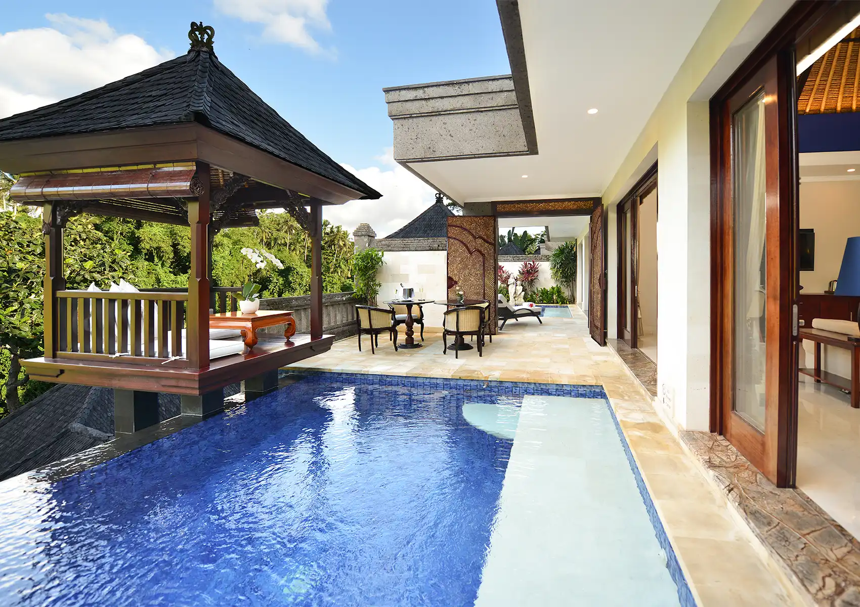 A luxurious private villa featuring an infinity pool, a traditional wooden gazebo, and an outdoor patio at a boutique hotel bali.